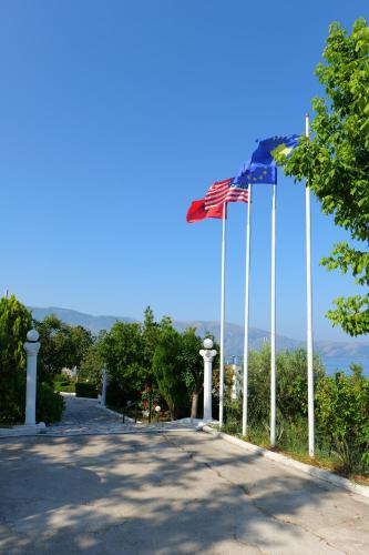 a road with an american flag on a pole at Edva Resort in Vlorë