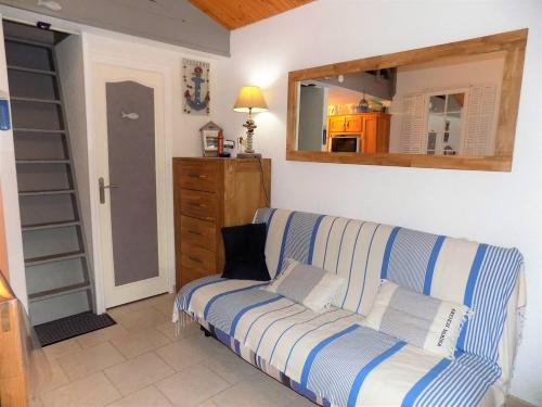 a living room with a couch and a mirror at La Palmyre - CHARMANTE VILLA MITOYENNE avec TERRASSE CLOSE in Les Mathes