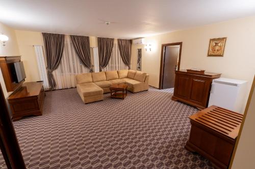 a living room with a couch and a television at Hotel Dorna in Vatra Dornei