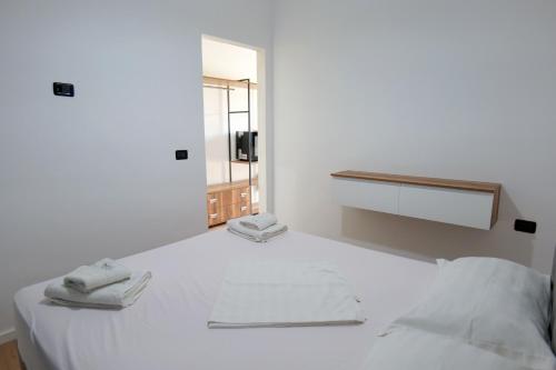 a white room with a bed with two towels on it at Edva Resort in Vlorë