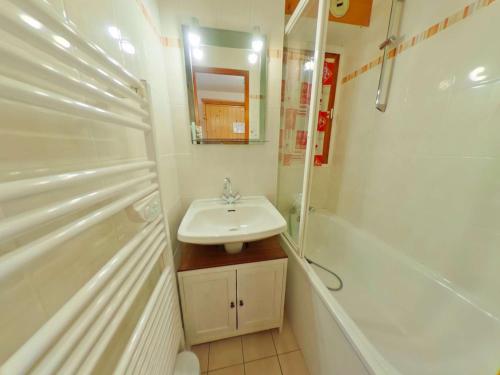 a bathroom with a sink and a tub and a mirror at Appartement Les Saisies, 2 pièces, 5 personnes - FR-1-594-92 in Hauteluce