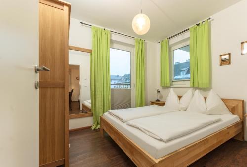 シュラートミンクにあるAppartement Lange Gasse by Schladming-Appartementsのベッドルーム1室(緑のカーテン付きのベッド1台付)