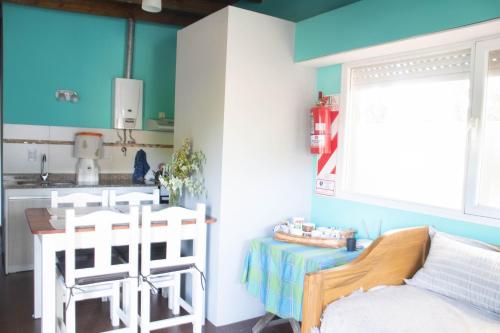 a kitchen with a table and chairs in a room at Cabañas El Viejo Sauce in Tandil