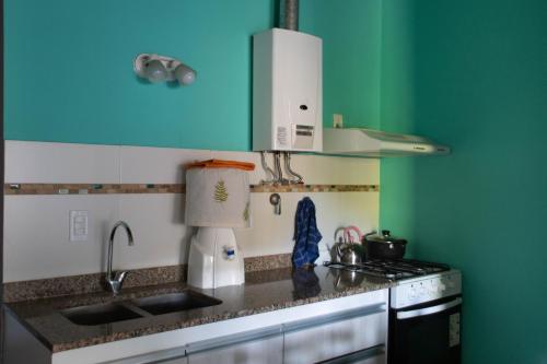 a kitchen with a sink and a stove top oven at Cabañas El Viejo Sauce in Tandil