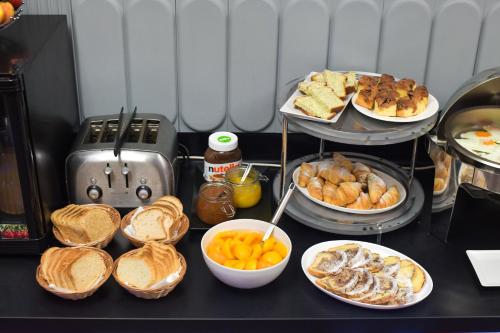 a table with plates of bread and bowls of food at ibis Styles Pitesti Arges in Piteşti