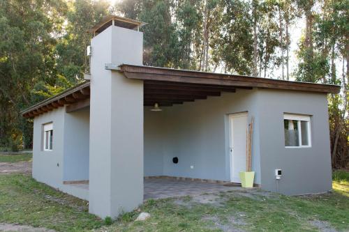 a small white building with a door at Cabañas El Viejo Sauce in Tandil