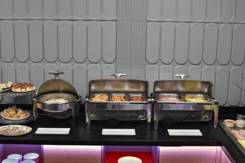 a buffet with several trays of food on a table at ibis Styles Pitesti Arges in Piteşti