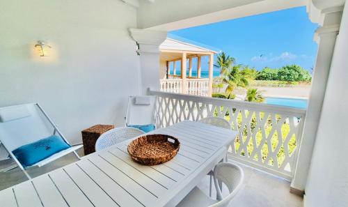 a table and chairs on a balcony with a view of the ocean at Riviera Blu Paradise Orient Bay in Orient Bay