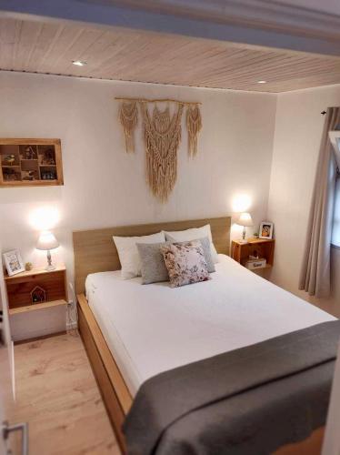 une chambre avec un grand lit blanc avec deux lampes dans l'établissement Isidaura, à Zutendaal