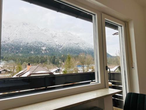 a window with a view of a snow covered mountain at The View Apartment in Garmisch-Partenkirchen