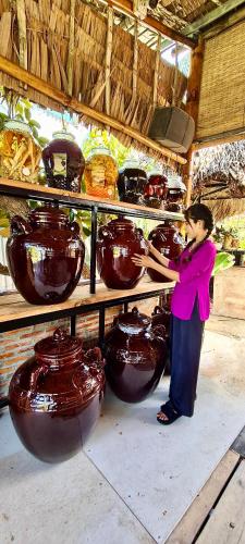 a woman standing in front of a display of vases at Song Ngư Riverside Homestay in Can Tho