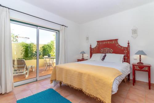 ein Schlafzimmer mit einem großen Bett und einem Balkon in der Unterkunft Townhouse nº30 with fantastic sea views in Ferragudo