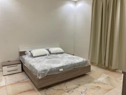 ein Schlafzimmer mit einem Bett und einem Nachttisch in der Unterkunft شاليه ألو in Al Bukayriyah