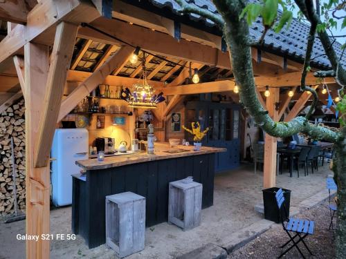 una cocina al aire libre con un bar en un edificio de madera en Charmecamping Domaine Bleu Celeste, en Couleuvre