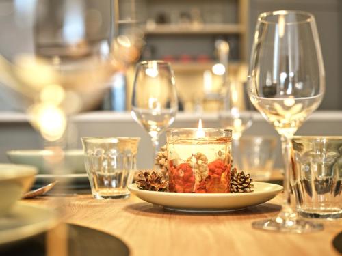 a table with a plate with a candle and wine glasses at The Tauplitz Suites - Alpine Suite B4 by AA Holiday Homes in Tauplitz