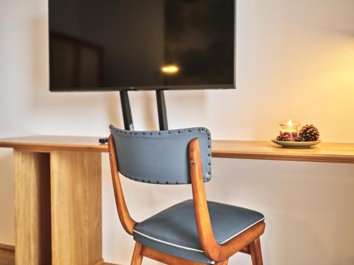 a chair in front of a desk with a television at The Tauplitz Suites - Alpine Suite B4 by AA Holiday Homes in Tauplitz