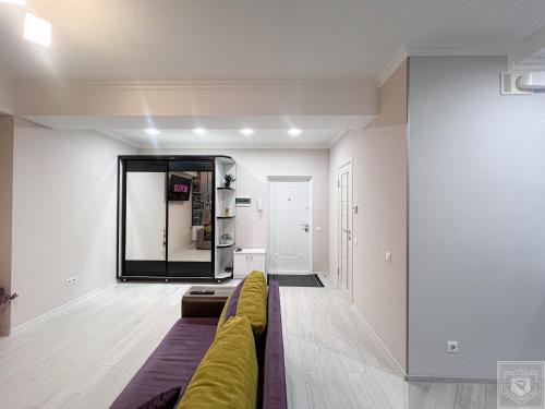a living room with a couch and a mirror at RentHouse Apartments Deep Purple in Chişinău
