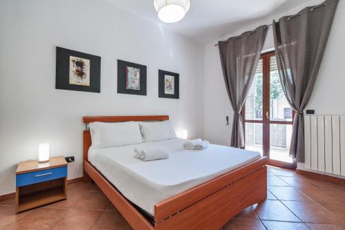 1 dormitorio con 1 cama con sábanas blancas y ventana en Le 2 Palme Family House - Lecce Selection, en Lecce