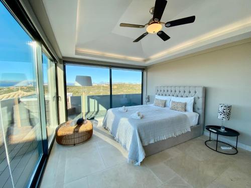 - une chambre avec un lit et un ventilateur de plafond dans l'établissement Quinta dos Caneiros Luxury villa Ocean views walk to beach, à Ferragudo