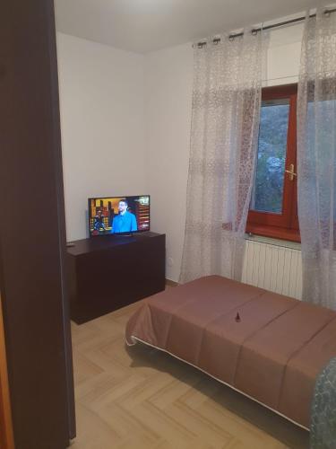 a living room with a bed and a television at B&B paradiso in Paganica
