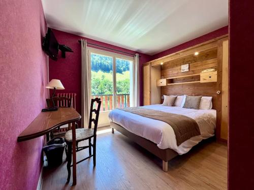 a bedroom with a bed and a desk and a window at Logis Hotels - Hôtel - Restaurant - Bar - Le Sapin Fleuri in Bourg dʼOueil