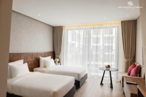 a hotel room with two beds and a window at Penthouse Apec Phú Yên in Liên Trì (3)