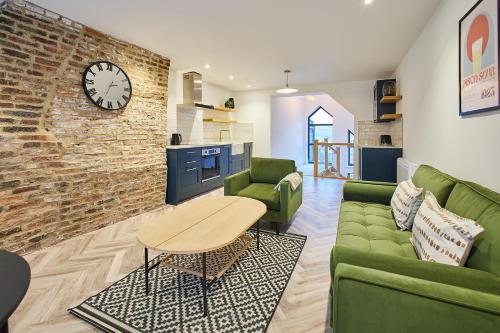 a living room with green furniture and a brick wall at Host & Stay - Flowergate Apartments in Whitby