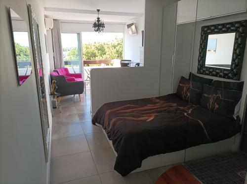 een slaapkamer met een groot bed en een woonkamer bij Village Naturiste Studio Luxe in Cap d'Agde