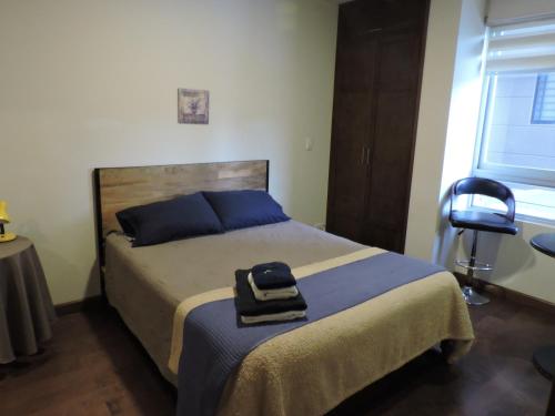 ein Schlafzimmer mit einem Bett mit einer Tasche darauf in der Unterkunft Altos del Parque/Espacio Ideal in Cochabamba