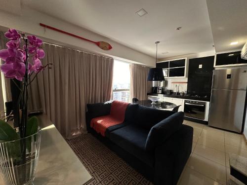 巴西利亚VISTA PARK SUL COBERTURA DUPLEX的客厅里有一张沙发和一个厨房