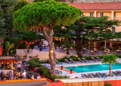 vistas a un patio con un árbol y una piscina en Les Jardins Du Cèdre, en Port-Vendres