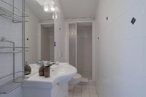 a white bathroom with a sink and a toilet at Pied-a-terre Saint Michel in Menton