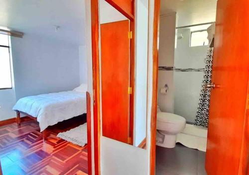 uma casa de banho com WC e uma cama num quarto em Delgado's home em Cusco