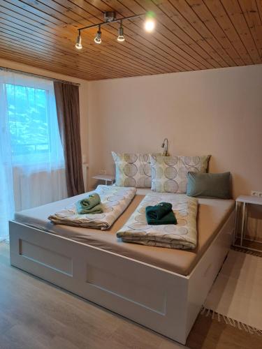 ein großes Bett mit zwei Kissen darauf in einem Schlafzimmer in der Unterkunft Alpenbauernhaus Konzett in Schruns-Tschagguns