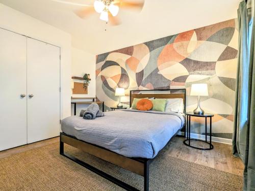 a bedroom with a bed with a mural on the wall at League Flats West End in Charlotte