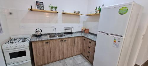 a kitchen with a white refrigerator and a sink at Nuestra Casa en Paso in Paso de la Patria