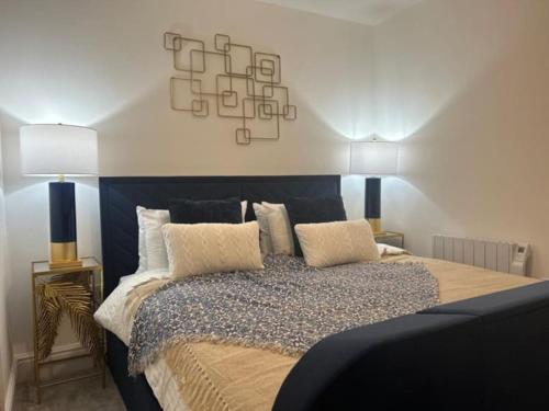 een slaapkamer met een groot bed met 2 lampen erop bij SunningEnd W King SBed EV Parking in Cheltenham