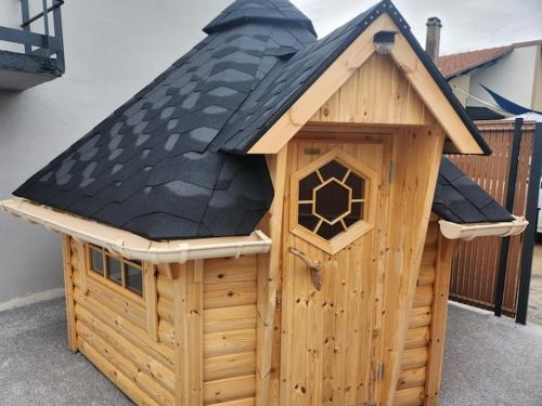 a wooden dog house with a black roof at le chalet 