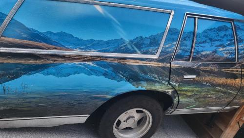 a van with a reflection of the mountains at le chalet 