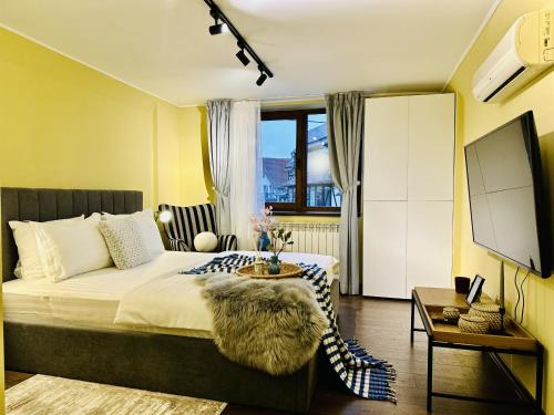 a bedroom with a large bed and a tv at 5 to stay close to the Castle in Bran