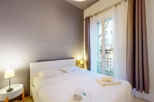 a bedroom with a white bed and a large window at Loft Gambetta 33 Fshh in Nice