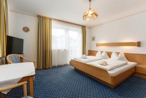 シュラートミンクにあるAppartement Wartinger by Schladming-Appartementsのベッドとデスクが備わるホテルルームです。