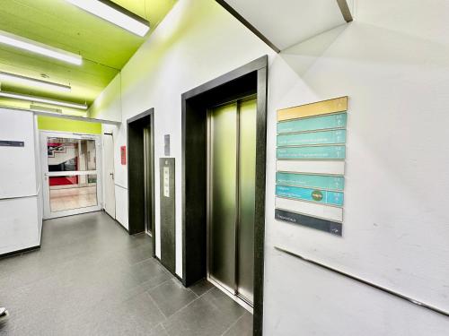 un pasillo de una oficina con paredes verdes y blancas en Garten Gästehaus en Leonberg