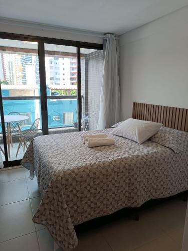 a bed with two towels on it in a bedroom at Barra Caravela Studio in Salvador