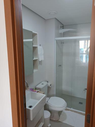 a bathroom with a toilet and a sink and a shower at Barra Caravela Studio in Salvador