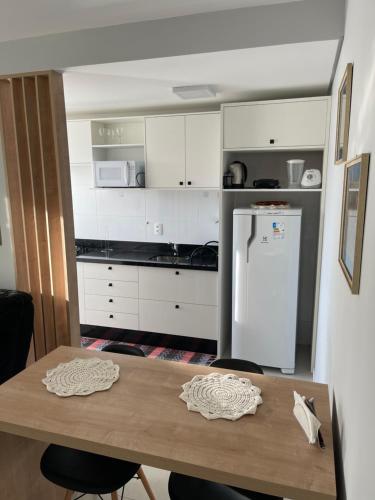 cocina con mesa y nevera blanca en Apt próximo a UFSC, en Florianópolis