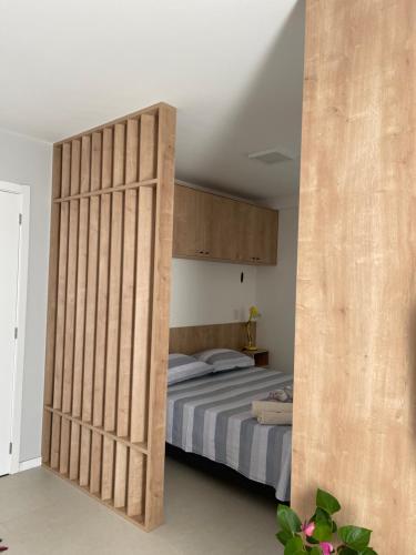 1 dormitorio con un tabique de madera y 1 cama en Apt próximo a UFSC, en Florianópolis