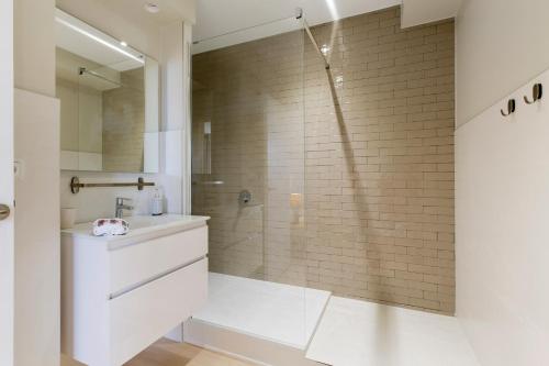 une salle de bain blanche avec une douche et un lavabo dans l'établissement La Roseraie Bidart, Piscine, Golf d Ilbaritz, à Bidart