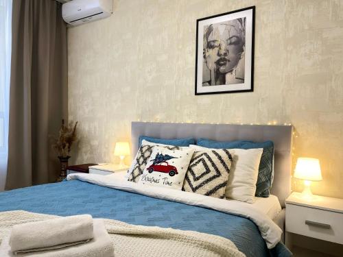 um quarto com uma cama azul e branca com almofadas em Затишна і тепла квартира, метро Лівобережна, МВЦ, Інститут Серця em Kiev