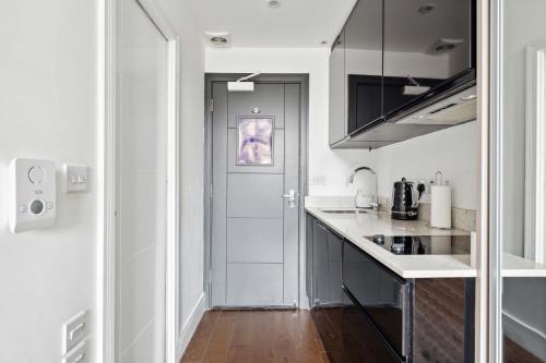 a kitchen with white counters and a white door at Golden Square in London
